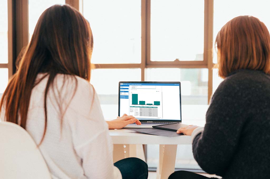 two woman reviewing prescription on laptop