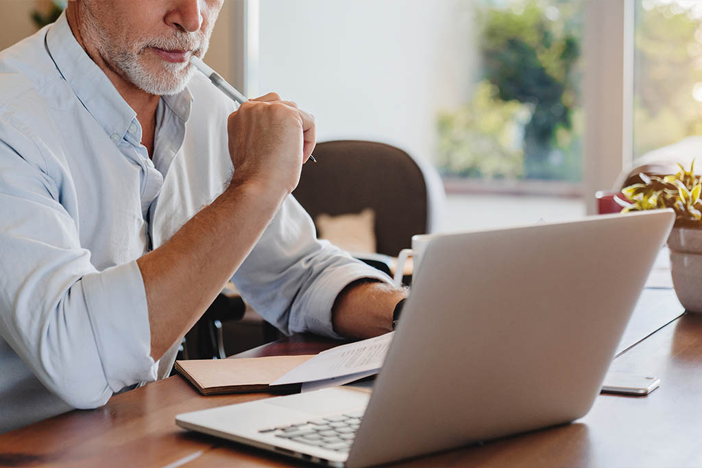 man reviewing treatment plan on laptop