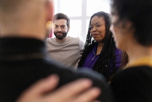 Diverse group of people standing in a huddle during therapy session. Multiracial group of people standing in circle.