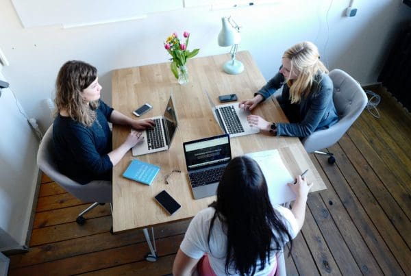 women working on laptops at desk