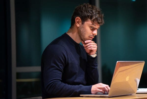 man starting PMHNP on his laptop