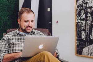 man opening PMHNP practice on his laptop